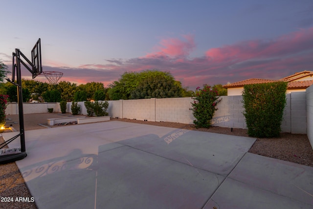 patio terrace at dusk featuring basketball court