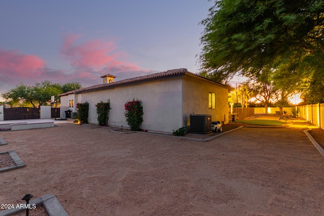 property exterior at dusk featuring central AC