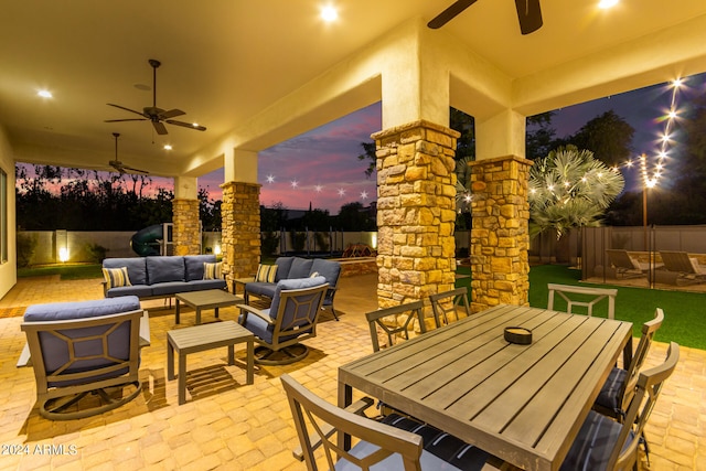 patio terrace at dusk with outdoor lounge area and ceiling fan