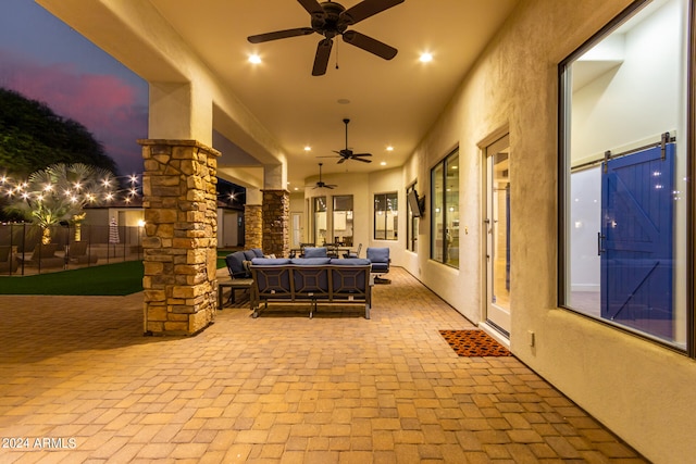 patio terrace at dusk with ceiling fan and an outdoor hangout area