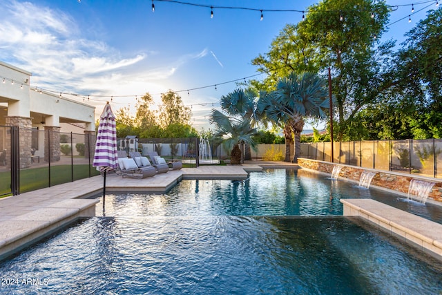 view of swimming pool with pool water feature and a patio