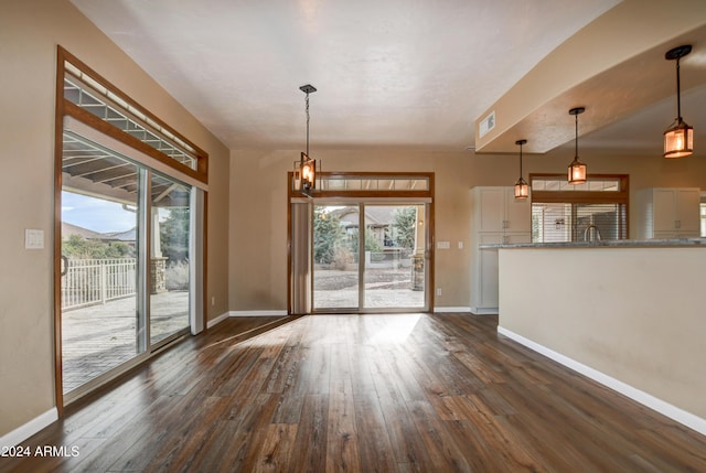 unfurnished dining area with dark wood-type flooring