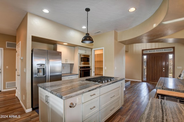 kitchen with white cabinets, dark hardwood / wood-style floors, decorative light fixtures, and appliances with stainless steel finishes