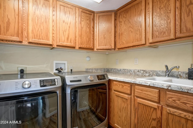 washroom with cabinets, independent washer and dryer, and sink