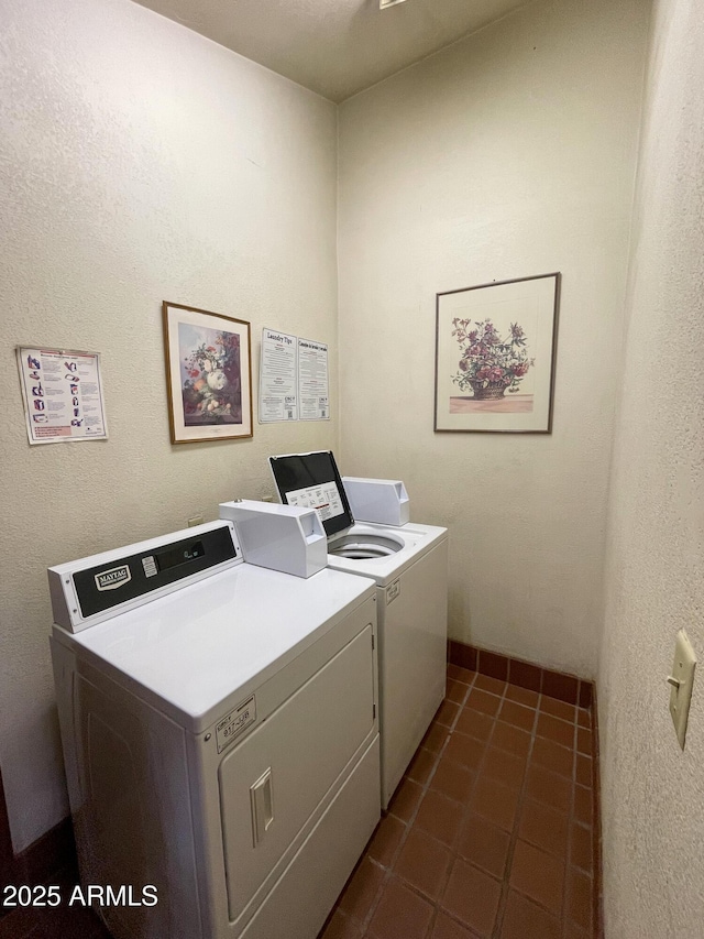 shared laundry area with dark tile patterned flooring and independent washer and dryer