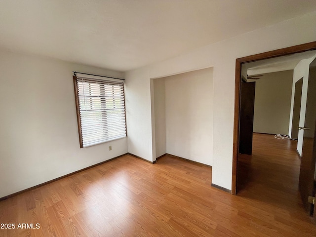 unfurnished room featuring light wood-style flooring and baseboards