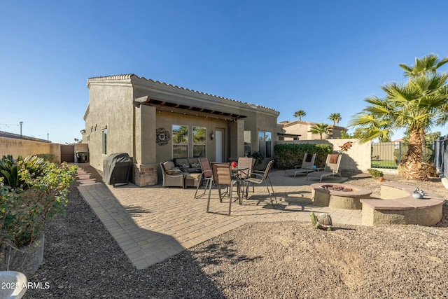 back of property with a patio and a fire pit