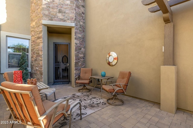 view of patio / terrace featuring ceiling fan and an outdoor stone fireplace