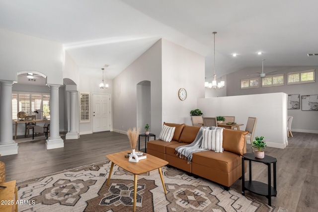 living room featuring arched walkways, ornate columns, and wood finished floors