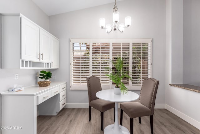 dining space featuring baseboards, a chandelier, and wood finished floors