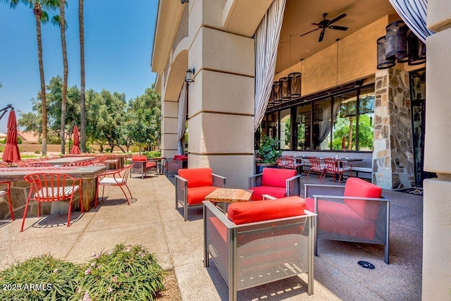 view of patio with outdoor dining area, an outdoor living space, and a ceiling fan