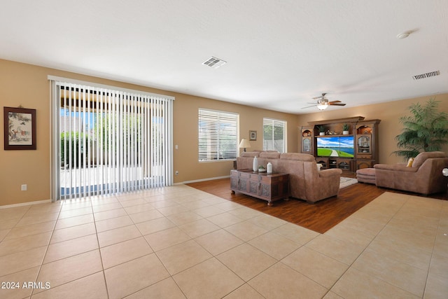 living area featuring light tile patterned floors, visible vents, and a healthy amount of sunlight