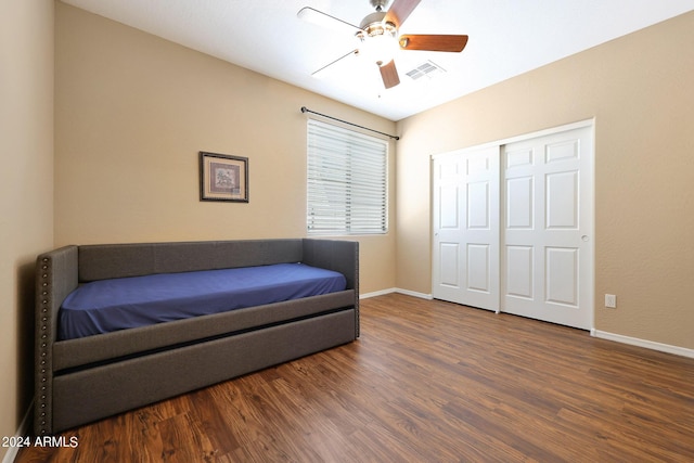 bedroom featuring baseboards, visible vents, dark wood-style floors, ceiling fan, and a closet