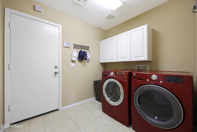 laundry room featuring cabinet space, baseboards, visible vents, and washing machine and clothes dryer