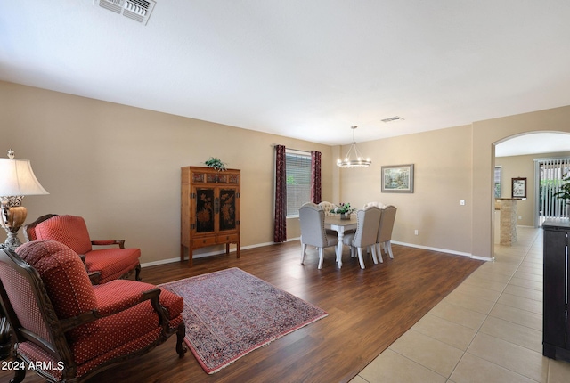 living room featuring a healthy amount of sunlight, light wood-style flooring, visible vents, and arched walkways