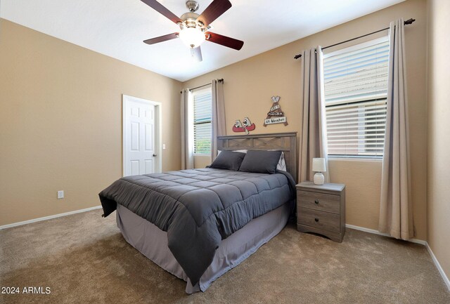 bedroom with light carpet, ceiling fan, and baseboards