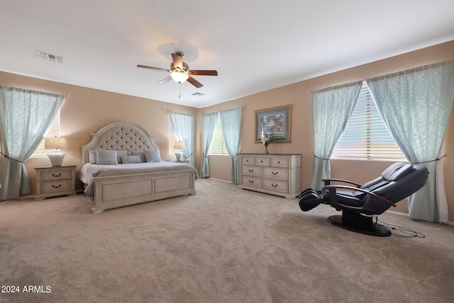 bedroom featuring visible vents, a ceiling fan, and light colored carpet