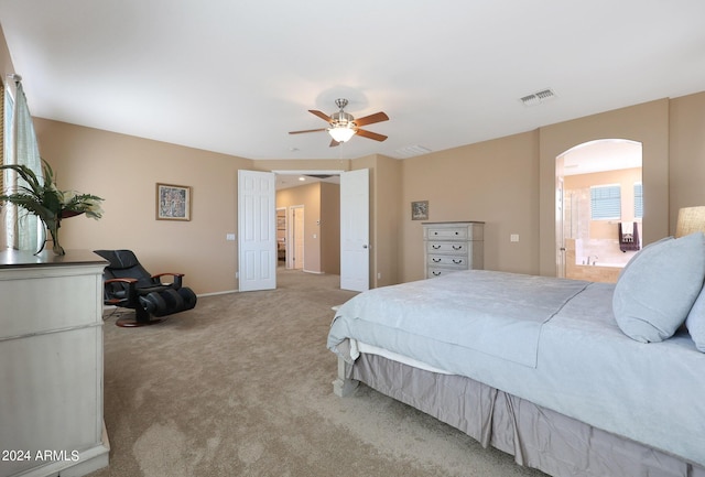 bedroom with arched walkways, visible vents, ceiling fan, and carpet