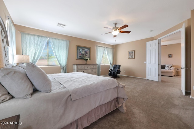 bedroom with light carpet, ceiling fan, visible vents, and baseboards