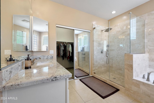 bathroom with a stall shower, tile patterned floors, a garden tub, a walk in closet, and vanity