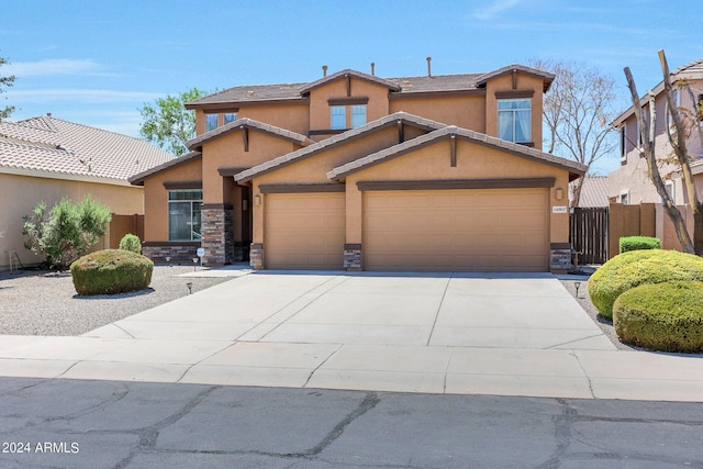 view of front facade featuring stucco siding, fence, a garage, stone siding, and driveway