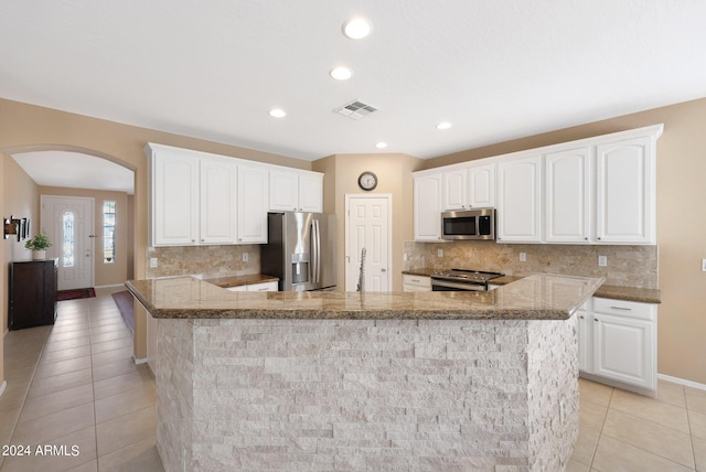 kitchen with a peninsula, white cabinetry, visible vents, and appliances with stainless steel finishes