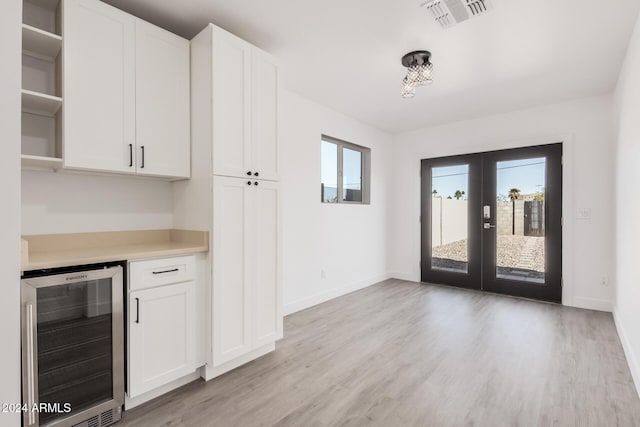 kitchen with white cabinetry, beverage cooler, and a wealth of natural light