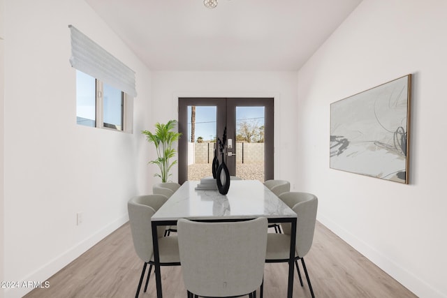 dining space with french doors and light hardwood / wood-style flooring