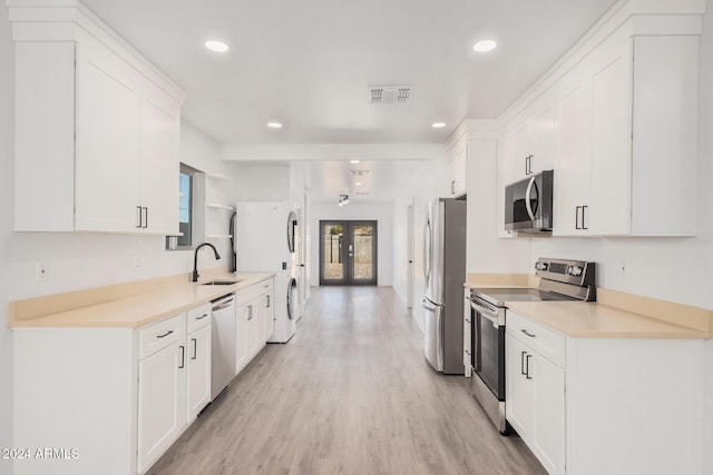 kitchen featuring french doors, appliances with stainless steel finishes, sink, and white cabinets