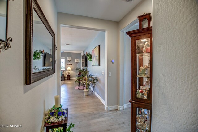 hallway with light wood-style flooring and baseboards