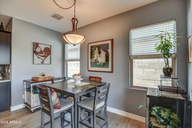 dining space featuring light wood-type flooring, baseboards, and visible vents