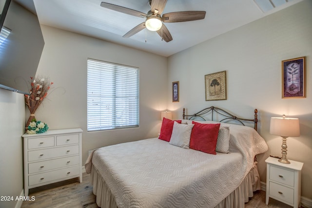 bedroom with a ceiling fan, light wood-type flooring, visible vents, and baseboards