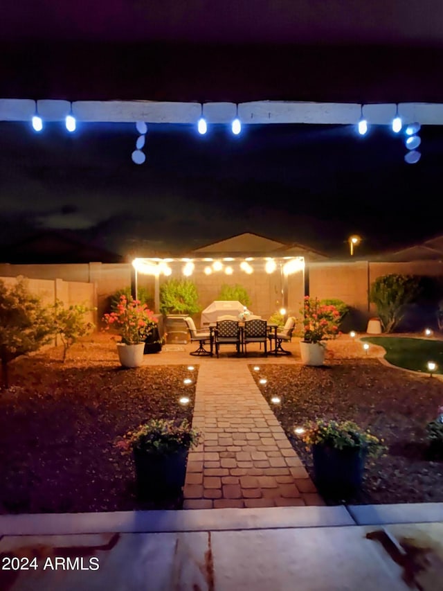 patio at twilight featuring a fenced backyard