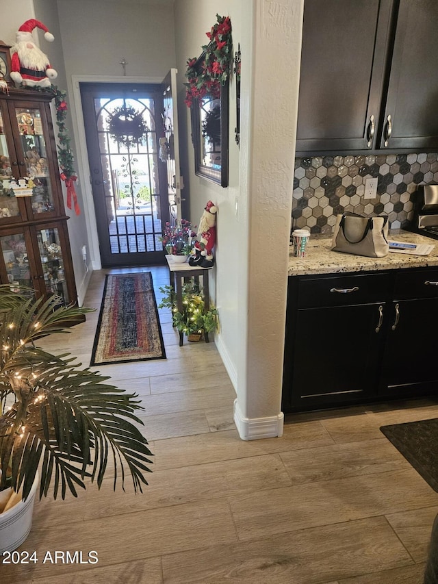 foyer featuring baseboards and light wood finished floors