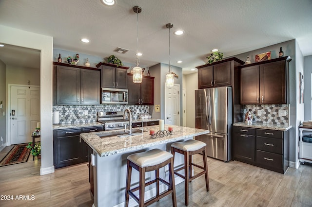 kitchen featuring dark brown cabinetry, visible vents, stainless steel appliances, and a sink