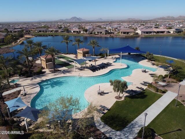 community pool with a patio area and a water view