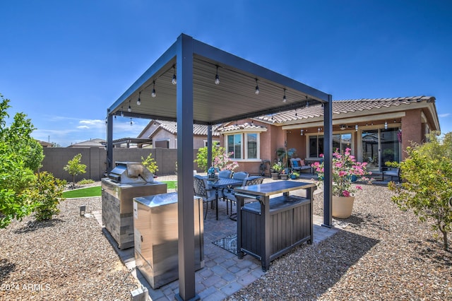 view of patio featuring grilling area, fence, and outdoor dining area