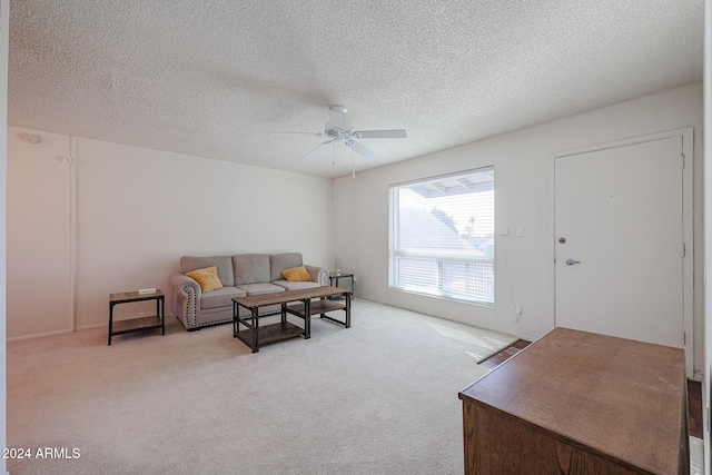 carpeted living room with a textured ceiling and ceiling fan