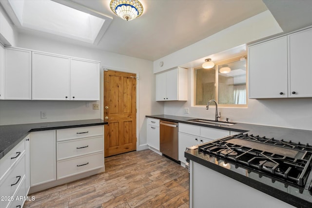 7813 N 17th Dr, Phoenix, AZ 85021 - kitchen featuring a skylight, dishwasher, light wood finished floors, a sink, and stovetop