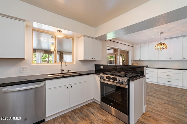 7813 N 17th Dr, Phoenix, AZ 85021 - kitchen with dark countertops, a sink, appliances with stainless steel finishes, and a healthy amount of sunlight