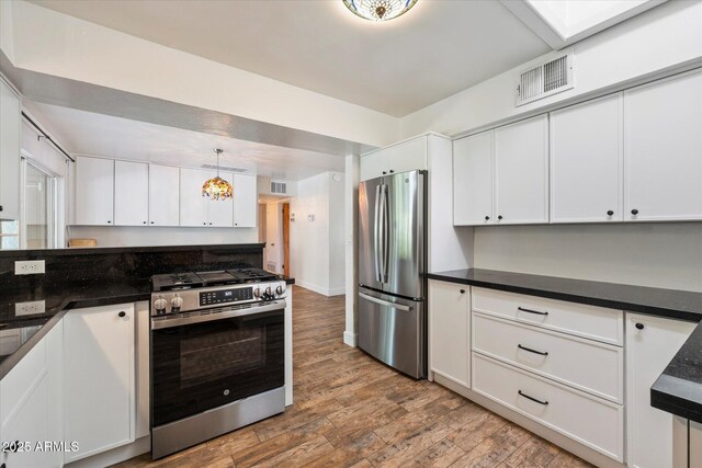 7813 N 17th Dr, Phoenix, AZ 85021 - kitchen with dark countertops, visible vents, appliances with stainless steel finishes, and wood finished floors