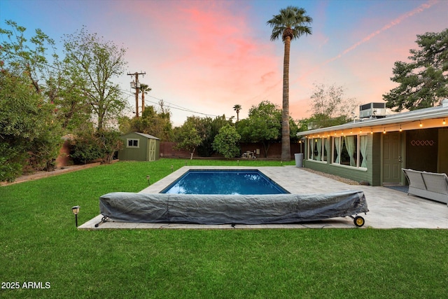 7813 N 17th Dr, Phoenix, AZ 85021 - pool at dusk featuring a patio, an outbuilding, a yard, a storage shed, and central AC