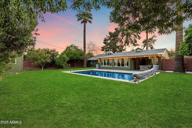 7813 N 17th Dr, Phoenix, AZ 85021 - back of property at dusk featuring a yard, a fenced backyard, and an outdoor pool