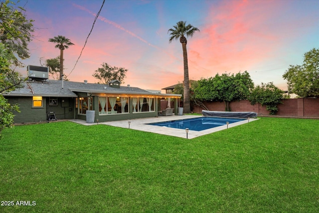 7813 N 17th Dr, Phoenix, AZ 85021 - pool at dusk featuring cooling unit, a patio, a fenced in pool, a yard, and a fenced backyard