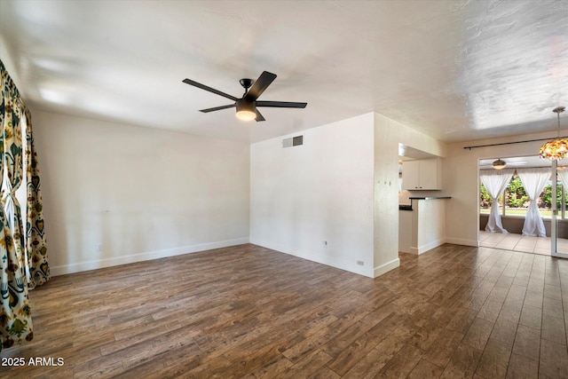 7813 N 17th Dr, Phoenix, AZ 85021 - unfurnished living room featuring dark wood finished floors, visible vents, ceiling fan with notable chandelier, and baseboards