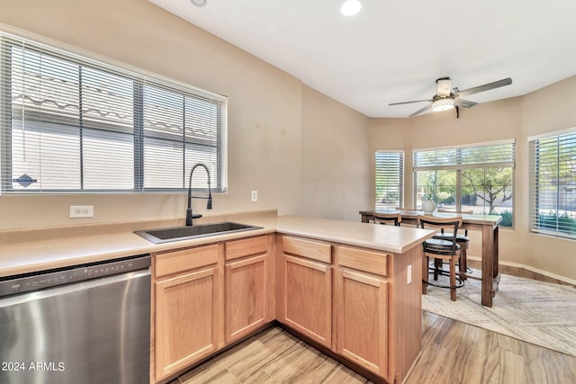 kitchen featuring ceiling fan, sink, light hardwood / wood-style floors, kitchen peninsula, and dishwasher