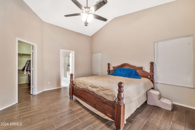 bedroom featuring ceiling fan, a walk in closet, a closet, dark hardwood / wood-style floors, and vaulted ceiling