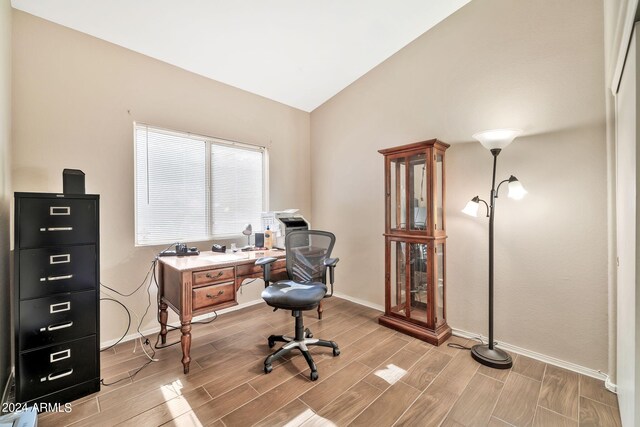 office area with light wood-type flooring and vaulted ceiling