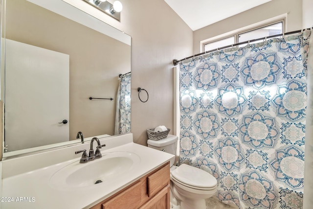 bathroom with a shower with curtain, vaulted ceiling, vanity, and toilet