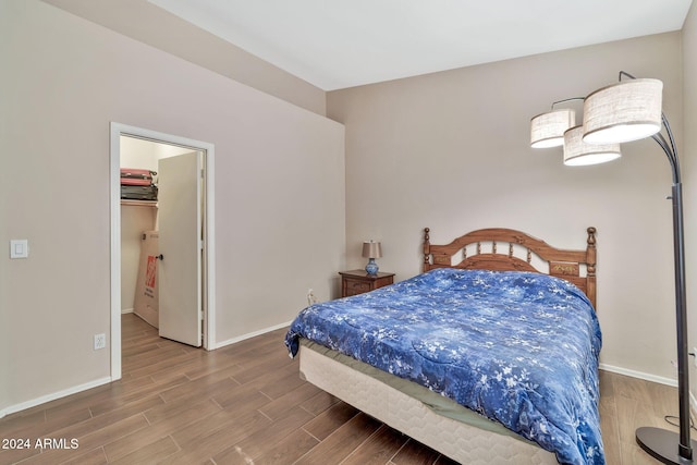 bedroom featuring a spacious closet and hardwood / wood-style floors